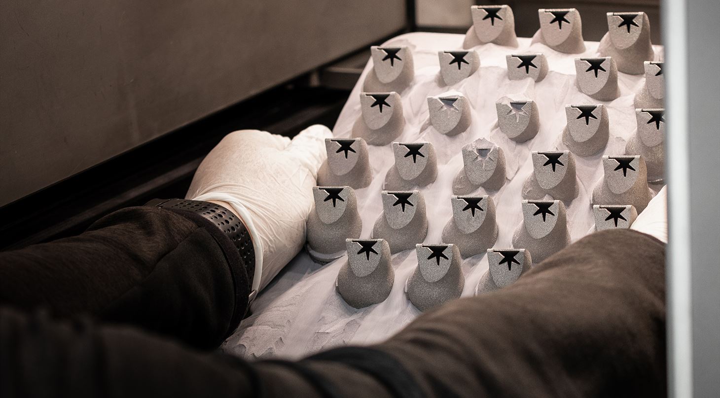 Hænder holder platform med 3D-printede emner